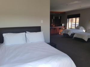 a bedroom with a large white bed and a living room at Tyday Accommodation in Port Elizabeth