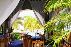 Suite Rivas 126 Gran Pacifica Resort في San Diego: مطعم بالطاولات الزرقاء والكراسي والنخيل