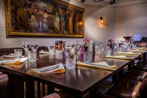 a long table in a room with glasses and napkins at The Castle Hotel, Conwy, North Wales - The Coaching Inn Group in Conwy