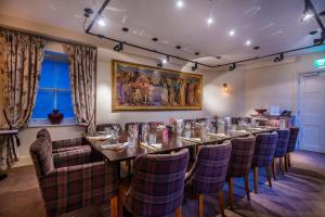 a dining room with a long table and chairs at The Castle Hotel, Conwy, North Wales - The Coaching Inn Group in Conwy