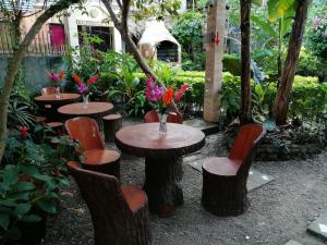 a group of tables and chairs in a garden at Ocean Breeze Inn in Boracay