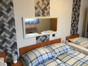 a bedroom with two beds and a mirror at Stella Vend&eacute;gh&aacute;z in Debrecen