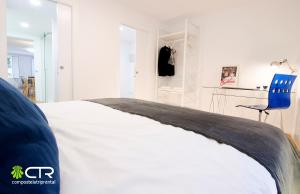 - une chambre avec un lit et une chaise bleue dans l'établissement Next to Cathedral with garden, à Saint-Jacques-de-Compostelle