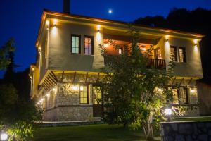 a house lit up at night with lights at Archontiko Lydia Lithos in &Oacute;rma