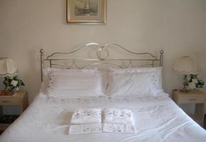 un letto con lenzuola bianche e due asciugamani sopra di AL PONTEROSSO a Trieste