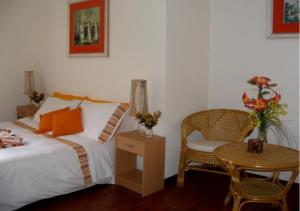 a bedroom with a bed and a chair and a table at AL PONTEROSSO in Trieste