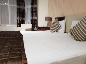 a bedroom with a large white bed with two pillows at Ascot Hotel in Douglas