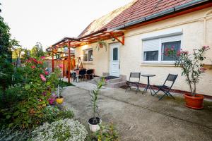 a house with a patio with chairs and a table at Havas Apartman in Eger