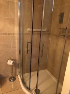 a shower with a glass door in a bathroom at San Juan B&B in Cloghran