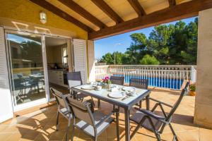 patio con mesa y sillas en el balcón en Villa del Mar, en Capdepera