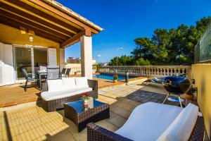 a patio with chairs and a grill on a deck at Villa del Mar in Capdepera