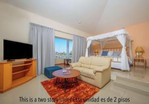 sala de estar con sofá, TV y cama en Isla Mazatlan Residence Club, en Mazatlán