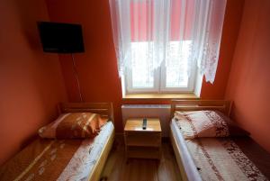 a small room with two beds and a window at Iskra in Augustów
