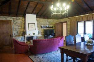 a living room with a table and chairs and a television at Casa De Santa Comba in Cabeceiras de Basto