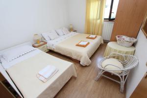 1 dormitorio pequeño con 2 camas y 1 silla en Apartments Milena, en Rovinj