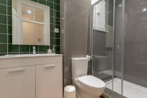 a bathroom with a toilet a sink and a shower at Carnot House in Setúbal