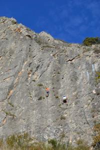 two people climbing up the side of a mountain at Tres Puentes Anguiano Apartamentos y Hostal in Anguiano