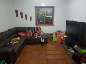 Mágico lugar en el Valle Sagrado في كوسكو: ثلاث فتيات يجلسن على الأريكة في غرفة المعيشة