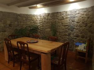 Mágico lugar en el Valle Sagrado في كوسكو: طاولة خشبية في غرفة مع جدار حجري +6 صور