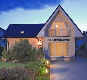 a house with a sign on the front of it at Vila Domino in Palanga