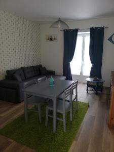 a living room with a table and a couch at Les Portes de Champagne in Bassevelle