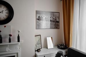 sala de estar con reloj en la pared y chimenea en Central Located One Bedroom Apt, en Bristol