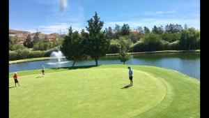 drie mensen die golfen op een golfbaan in de buurt van een vijver bij MARBELLA - ALICATE BEACHFRONT Apartment - 6 in Marbella