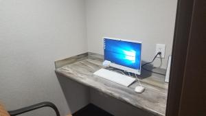 ein Computermonitor, eine Tastatur und eine Maus auf dem Schreibtisch in der Unterkunft Oak Hill Inn & Suites in Canton