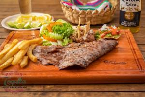 une assiette de nourriture avec de la viande et des frites dans l'établissement HOTEL RESTAURANTE TEQUILA, à Jalpan de Serra