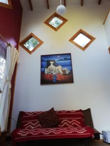1 dormitorio con 1 cama con una foto en la pared en Cabañas Kalfucura, en Licán Ray