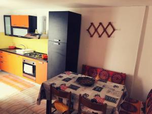 een keuken met een tafel en een keuken met een koelkast bij Casa vacanze Arimondi in Porto Cesareo