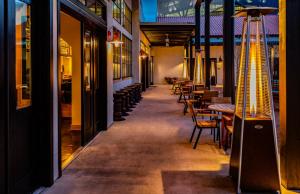 a corridor of a restaurant with tables and chairs at Texican Court, by Valencia Hotel Collection in Irving