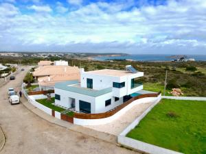 a white house with a car parked in front of it at Sunrise Villa in Sagres