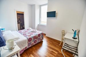 a bedroom with a bed and a table and a window at B&B HomEitaly Civitavecchia in Civitavecchia