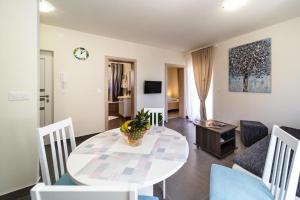 a dining room and living room with a table and chairs at Apartments LeonDori in Krk