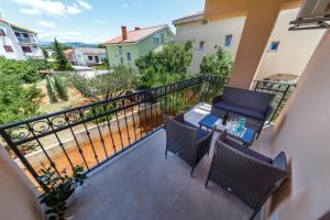 a balcony with a table and chairs on a balcony at Apartments LeonDori in Krk