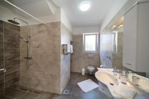 a bathroom with a sink and a shower and a toilet at Apartments LeonDori in Krk +49 photos