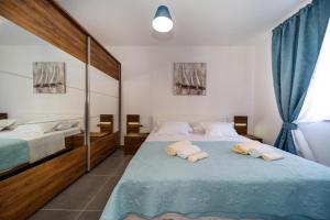a bedroom with two beds with towels on them at Apartments LeonDori in Krk