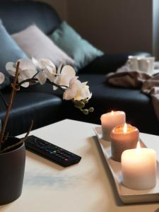 uma mesa com velas e um controle remoto e flores em BGY Central Apartments em Bérgamo