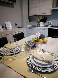 a dining table with plates and wine glasses on it at BGY Central Apartments in Bergamo