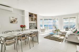 a white living room with a table and chairs at Luxurious Penthouse with panoramic view in Villefranche-sur-Mer