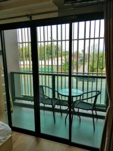 a room with a table and chairs and a balcony at La La Moon Krabi Poshtel'n' Pool in Krabi