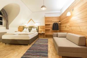 sypialnia z 2 łóżkami i kanapą w obiekcie Hotel-Restaurant-Café Krainer w mieście Langenwang