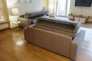 sala de estar con 2 sofás y TV de pantalla plana en Casa delle colonne by Home a porter, en Turín
