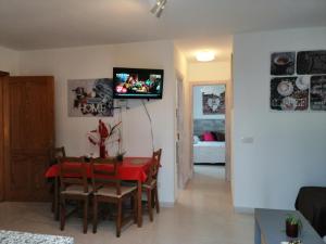 un soggiorno con tavolo e TV a parete di Apartamento Anaca 2 a Playa Blanca