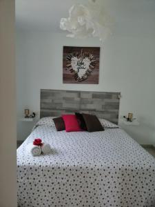 una camera da letto con un grande letto con lenzuola bianche e cuscini rosa di Apartamento Anaca 2 a Playa Blanca