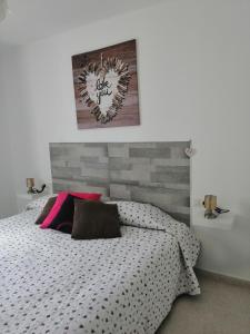 una camera con un letto e una foto appesa al muro di Apartamento Anaca 2 a Playa Blanca