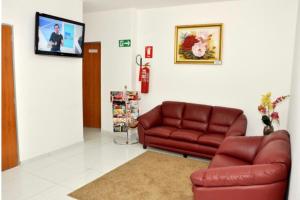 un soggiorno con divano e TV a schermo piatto di HOTEL 44 a Goiânia