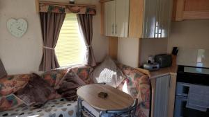 a living room with a couch and a table in a kitchen at 6 Berth Promanade Ingoldmells Arizona in Ingoldmells