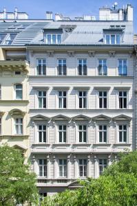 ein großes weißes Gebäude mit Fenstern und Bäumen in der Unterkunft Hotel Spiess & Spiess in Wien